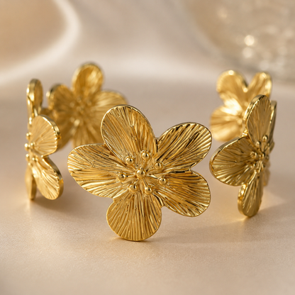 「XINXINIO」 花咲くゴールドブレスレット バングル 手元に咲く 金色の花 フラワーモチーフ